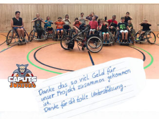 Die Juniors präsentieren das angeschaffte Handbike in der Sporthalle.